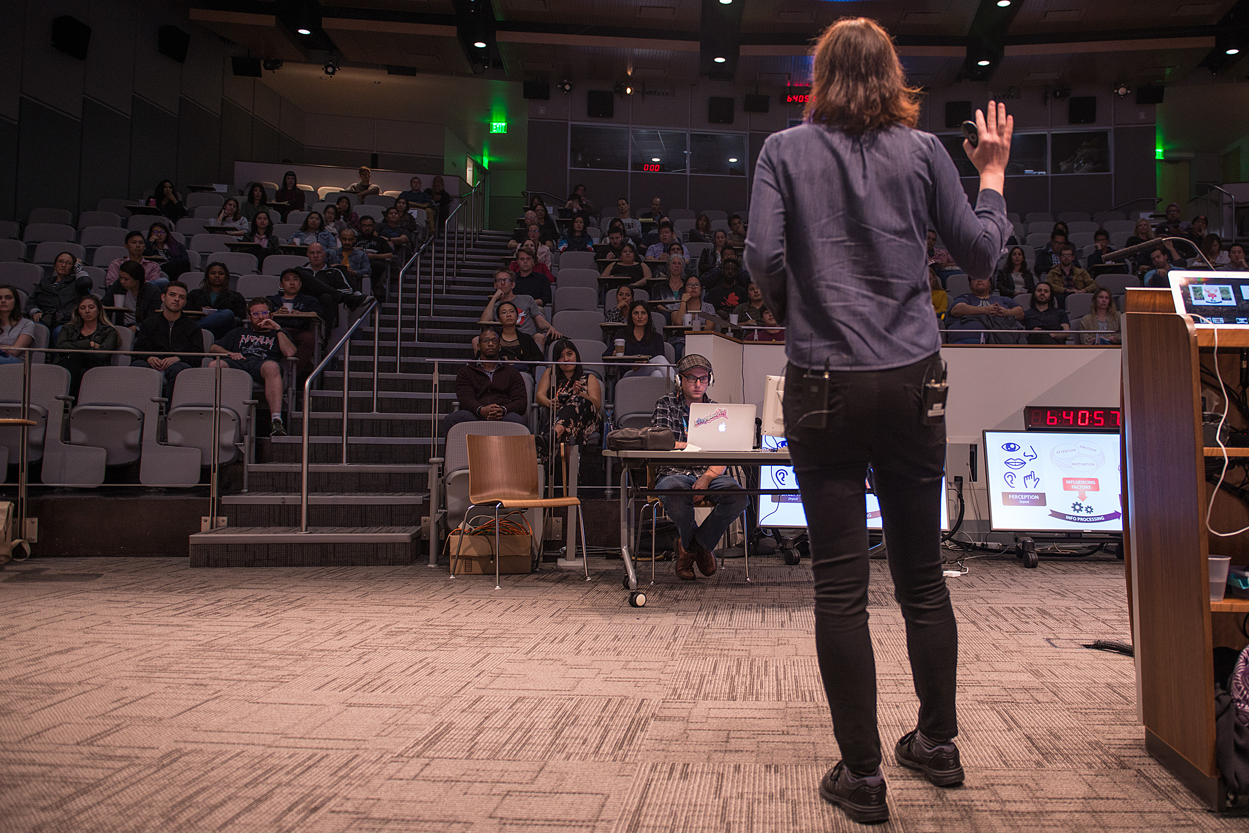 A UX Speakeasy speaker addressing a full lecture-hall audience